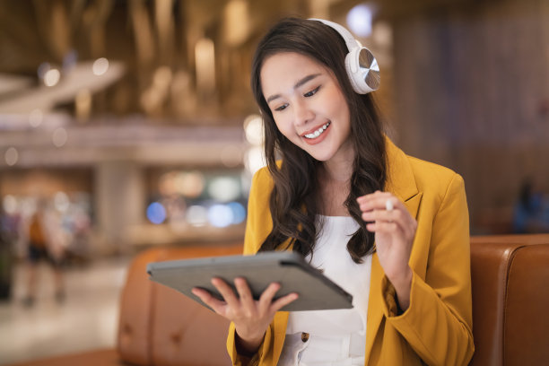 亚洲女性自由数字游牧民职业幸福工作开朗微笑在线工作与智能设备平板电脑智能手机国外职业项目工作在任何地方新的无框生活方式咖啡馆图片下载