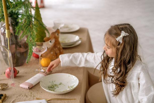 卷发女孩帮助布置节日餐桌庆祝圣诞节图片下载