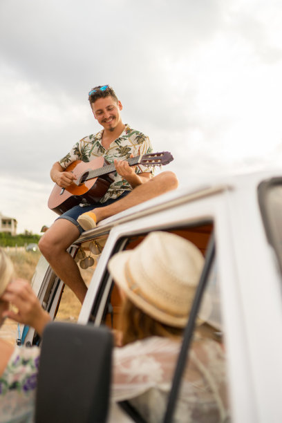 一个人坐在露营车顶上弹吉他图片下载