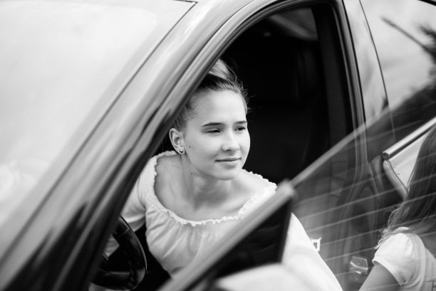 两个姐妹在车里。姑娘们在车旁鬼混呢。这个女孩陪着她的妹妹图片下载