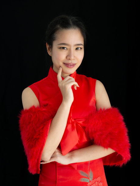 肖像美丽开朗快乐的亚洲妇女穿着红色服装，摆姿势，微笑，独自站在孤立的黑色背景切割和复制广告空间，庆祝中国新年图片下载