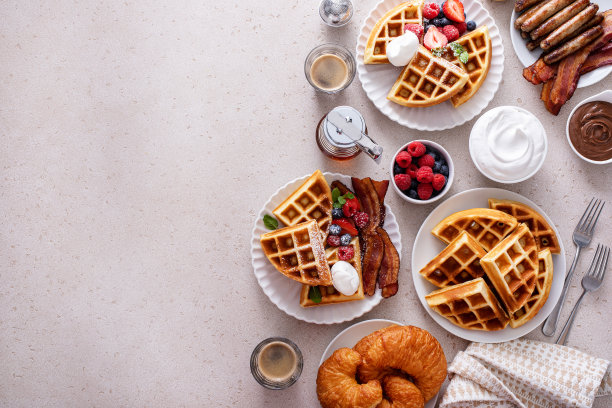 早餐桌上有华夫饼、牛角面包和培根图片下载