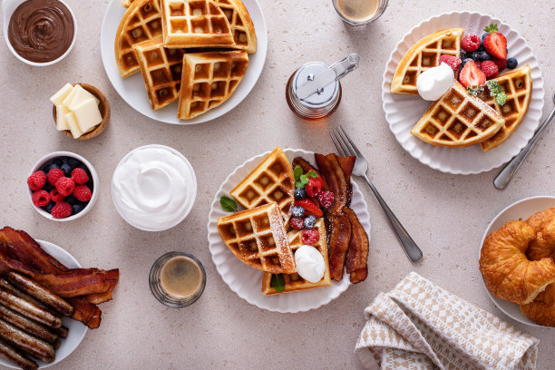 早餐桌上有华夫饼、牛角面包和培根图片下载