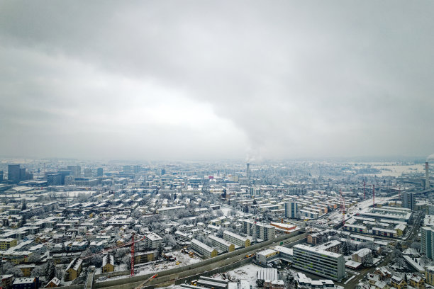 Aerial view over snow covered north part City of Zürich with skyline and gray cloudy winter sky on a snowy late autumn day.图片下载