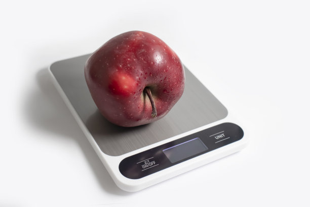 厨房磅秤，苹果在浅色背景上图片下载