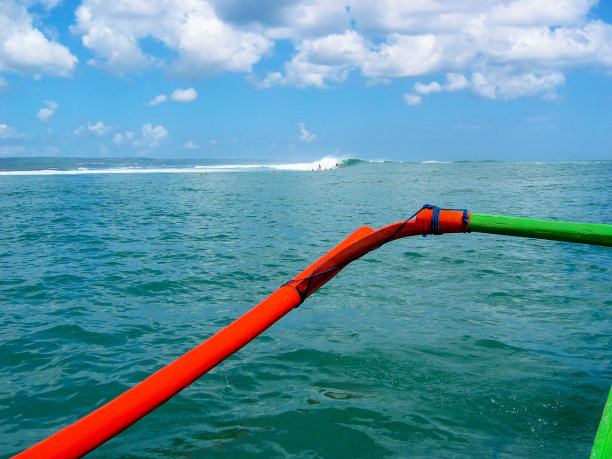 冲浪者和游客在机场和库塔礁的破浪礁上使用的木制帕拉胡船或普拉胡船图片下载