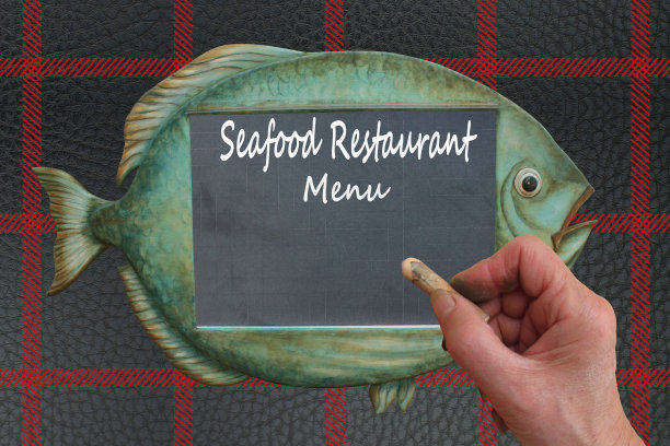 海鲜餐厅用粉笔在一块鱼形状的石板上手写菜单图片下载