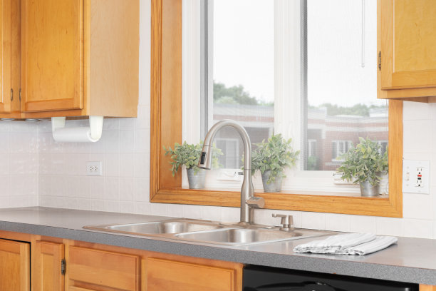 木制橱柜周围的厨房水槽龙头。图片下载