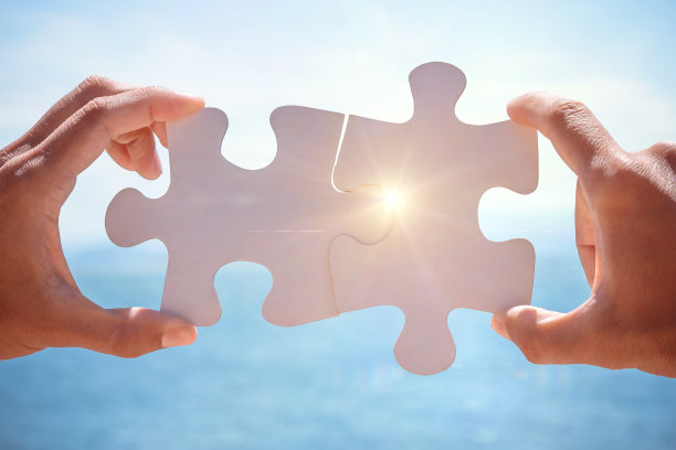 手连接拼图在大海的背景。概念旅游，度假，探险图片下载