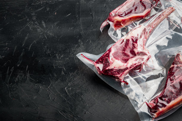 生牛肉牛排在真空包装空气密封真空袋装，战斧，t骨和俱乐部牛排削减，在黑色石头背景，与文本复制空间图片下载
