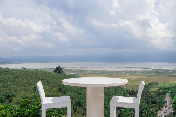 空荡荡的白色桌椅，美丽的背景和多云的天空。图片下载