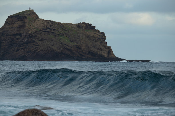 大西洋上的巨浪登陆，背景中可见葡萄牙马德拉岛上的波尔图莫尼兹镇。图片下载