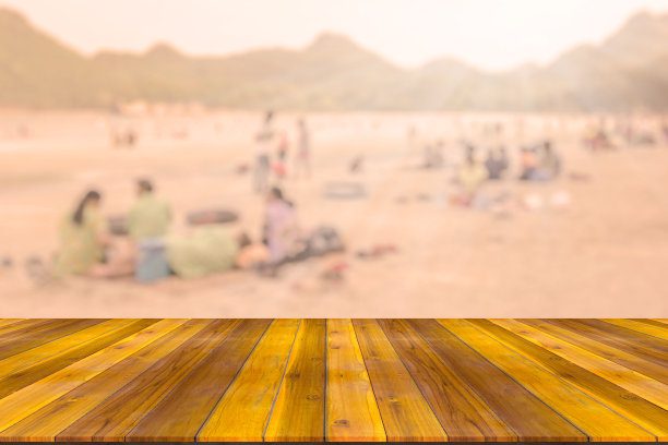 空旷的木板空间平台与海滩上许多人模糊的背景图片下载