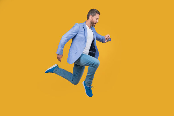 职业男人赶时间。英俊男子在半空中检查手表。精力充沛的人冲图片下载