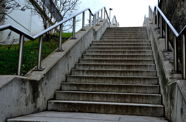 公共建筑的混凝土楼梯。安全楼梯有两个扶手，其中一个在学校入口处为12岁以下儿童降低了高度，无人机视角，顶部，点图片下载