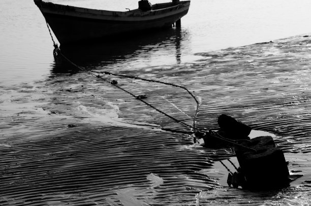 印度马哈拉施特拉邦西海岸阿里包格海滩上停泊的渔船的单色黑白照片。图片下载