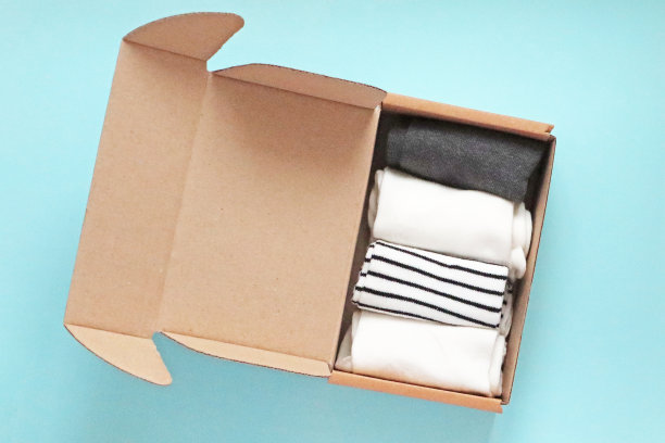 手工纸板盒容器与袜子在蓝色的背景图片下载