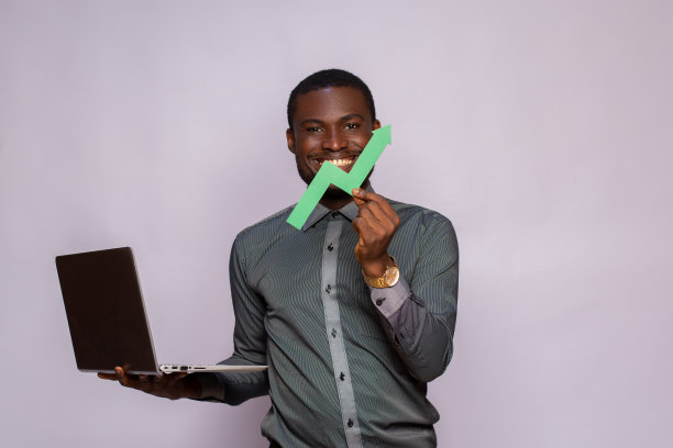 一个黑人拿着笔记本电脑和一个向上的图形符号，标志着进步图片下载