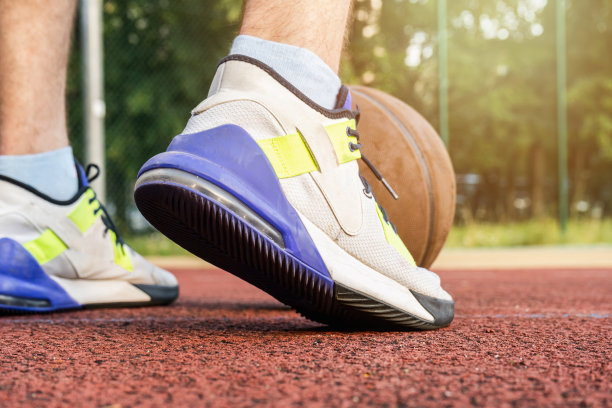 在球场上持球的篮球运动员。近距离图片下载