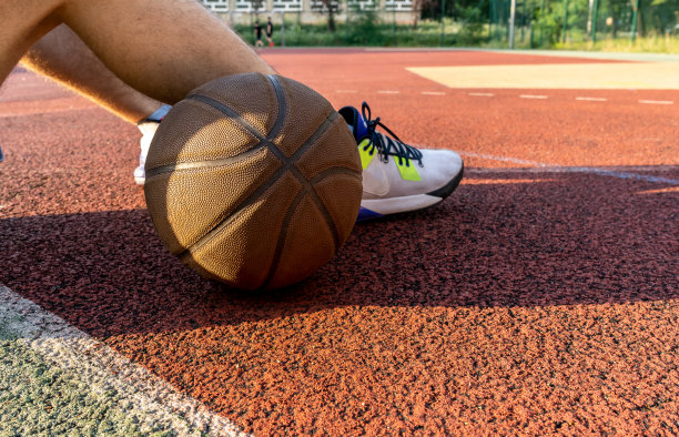 在球场上持球的篮球运动员。近距离图片下载