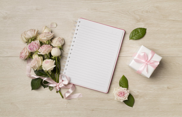 笔记本，礼品盒和玫瑰花的木质背景，顶视图图片下载