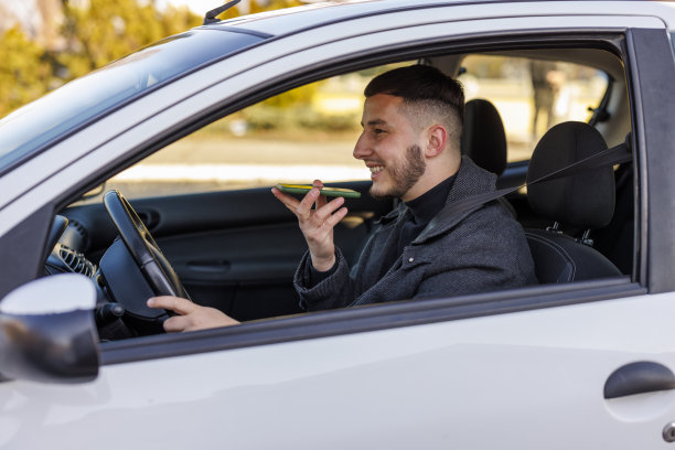 一位年轻英俊的男子一边用手机交流，一边准备乘车。图片下载