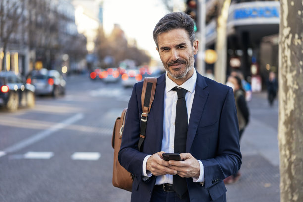 成熟的商人在街上使用智能手机图片下载