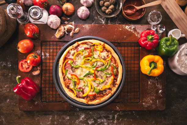 在木桌上的披萨配料和香料准备的俯视图，在家里的厨房里自制披萨烹饪。图片下载