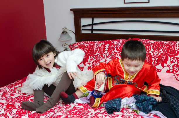 两个多种族的孩子(中国人和白人)睡在父母的床上图片下载