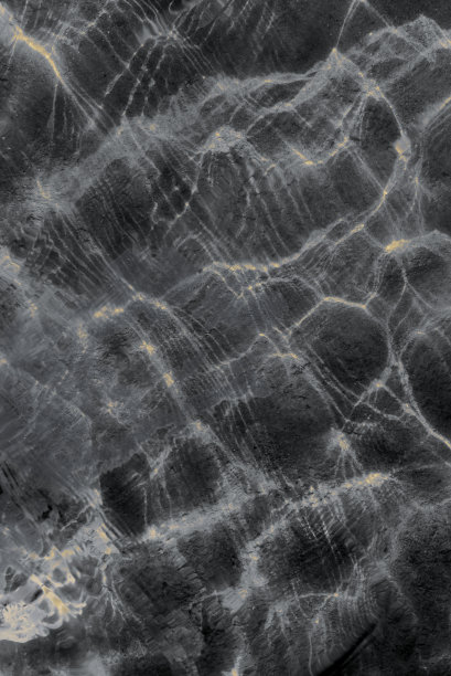 阳光从波浪中反射出来的透明水面的辉光的抽象照片。垂直的框架。背景图片下载