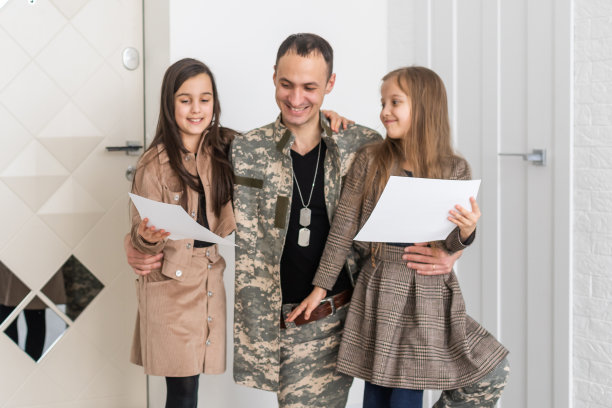 快乐的军人父亲抱着女儿。家庭、亲情和爱国主义。图片下载