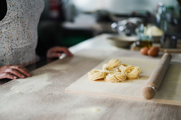女人准备面团在意大利面食工厂内馄饨-专注于意大利面图片下载