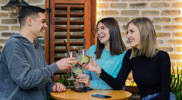 年轻人在酒吧里玩得很开心——朋友们一起喝鸡尾酒图片下载