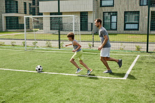 侧面看父亲和儿子一起踢足球图片下载