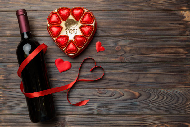 情人节彩色背景红酒，礼品和巧克力。心形的礼盒巧克力顶部视图与复制空间图片下载