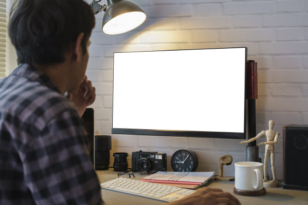 男摄影师在工作站的专业电脑上工作的后视图。图片下载