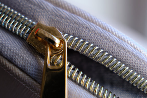 选择性聚焦，黄色金属拉链的化妆包或小钱包的宏观图案背景图片下载