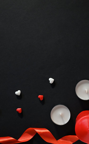 黑色背景上的心形和蜡烛。庆祝情人节、母亲节的概念图片下载