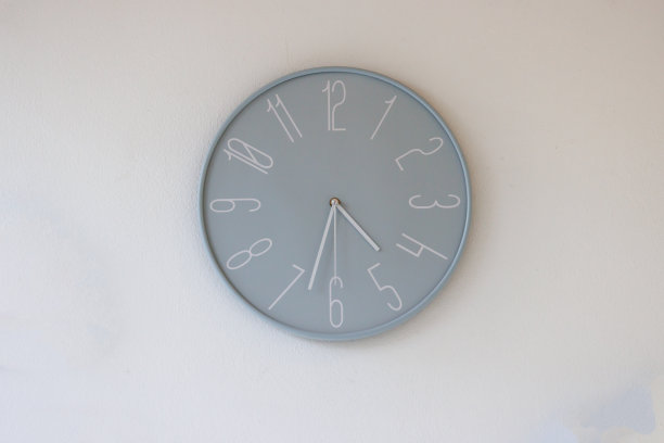 儿童学校白墙上的蓝色塑料钟。蓝色的钟墙。图片下载