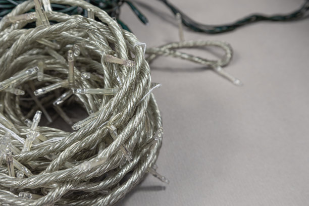 串圣诞彩灯储存。整齐地包裹在米色背景与空间文本花环图片下载