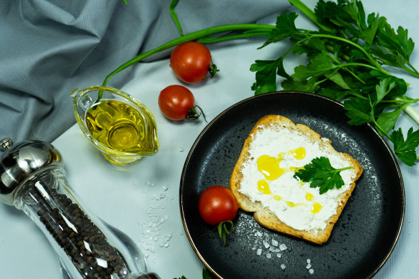 面包片，三明治，红番茄，盐瓶，绿色蔬菜。用有机农产品做早餐或零食的概念。三明治配新鲜西红柿。有选择性的重点。图片下载