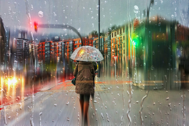 西班牙巴斯克地区毕尔巴鄂市的人们在雨天打着伞图片下载