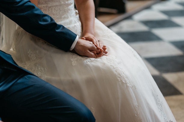 在教堂举行的婚礼上，新郎新娘手牵着手图片下载