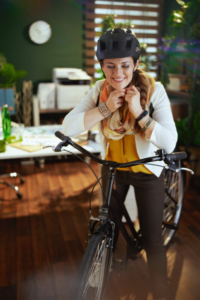 微笑的商业妇女在自行车头盔在生态办公室图片下载