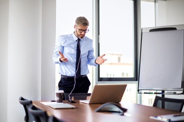 沮丧的商人在办公室用手机和笔记本电脑图片下载