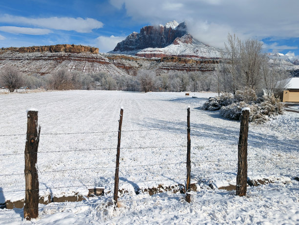 雪后在犹他州洛克维尔的牧场房子和果园，锡安国家公园的基内萨瓦山为背景图片下载