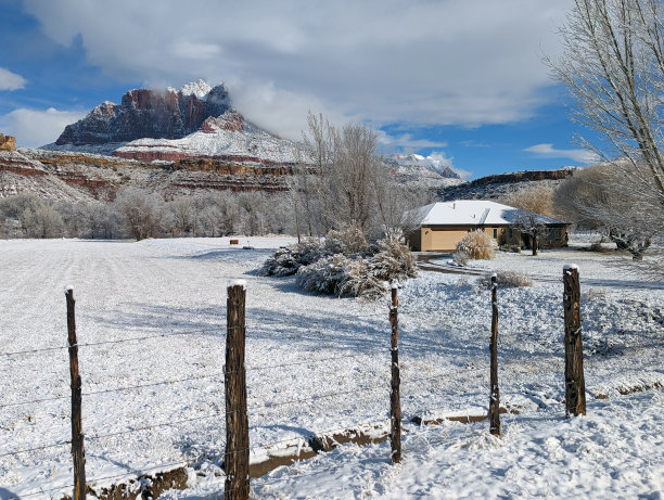 雪后在犹他州洛克维尔的牧场房子和果园，锡安国家公园的基内萨瓦山为背景图片下载
