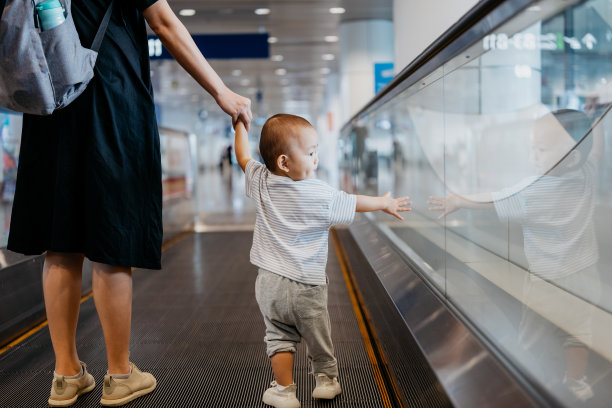 亚洲家庭在机场的移动走道上图片下载