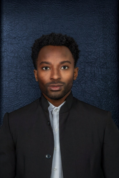 年轻男子在他的二十出头的头部黑色背景垂直工作室肖像图片下载