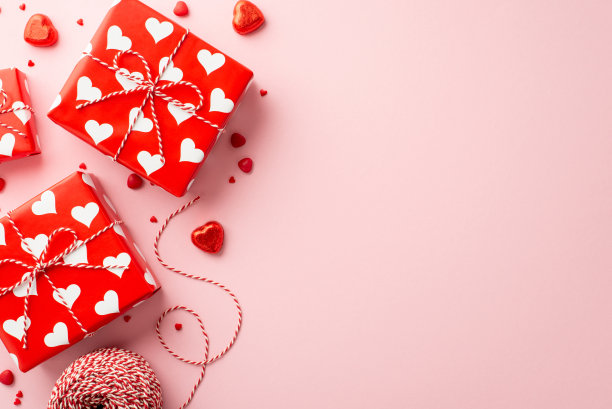 情人节的概念。目前盒子的顶部视图照片心形糖果线轴的麻线和洒在孤立的粉彩粉红色背景与空白图片下载